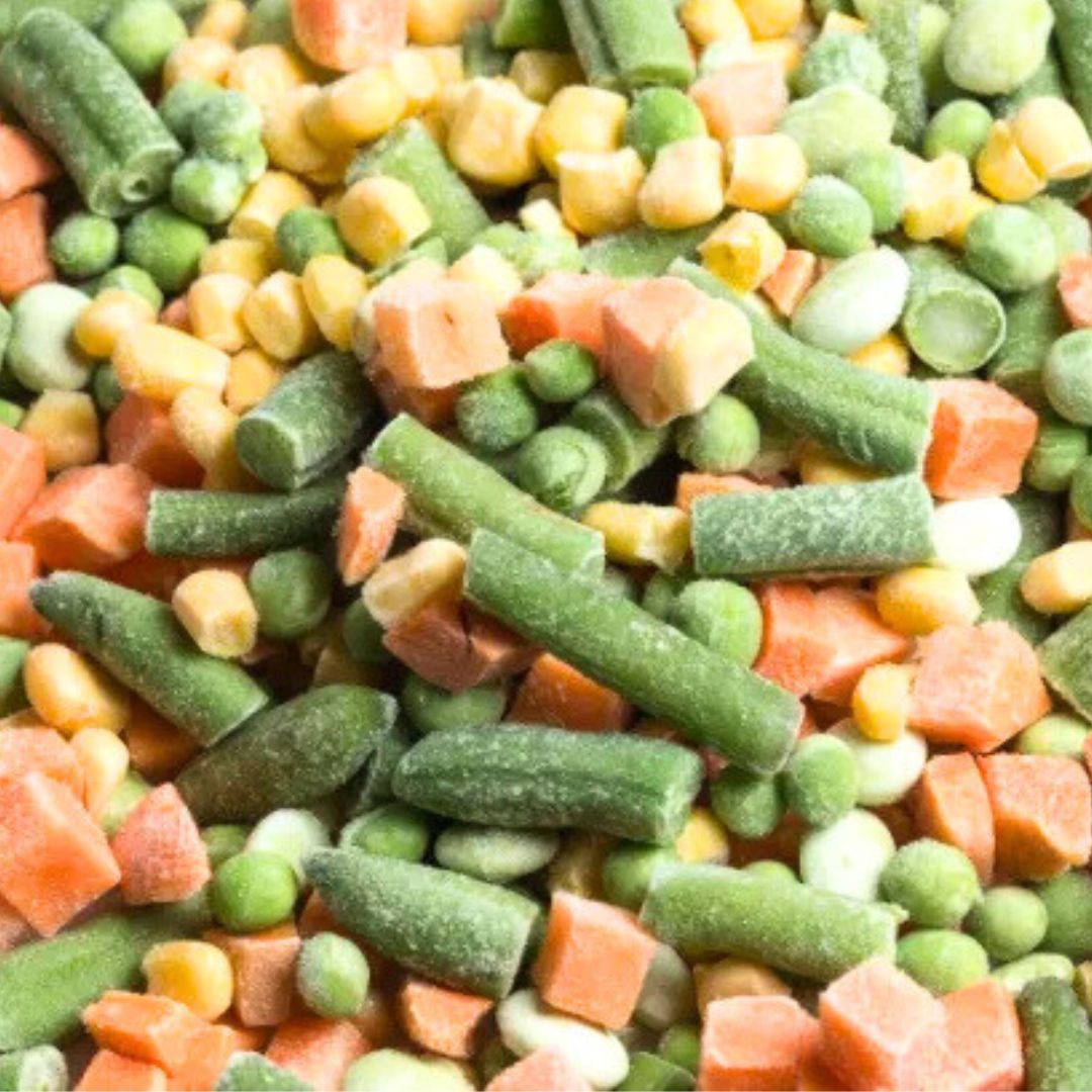 frozen mixed vegetables for exporting is placed on a plate but the view is of closed up shot of the mixed vegetables like beans peas carrot and corn